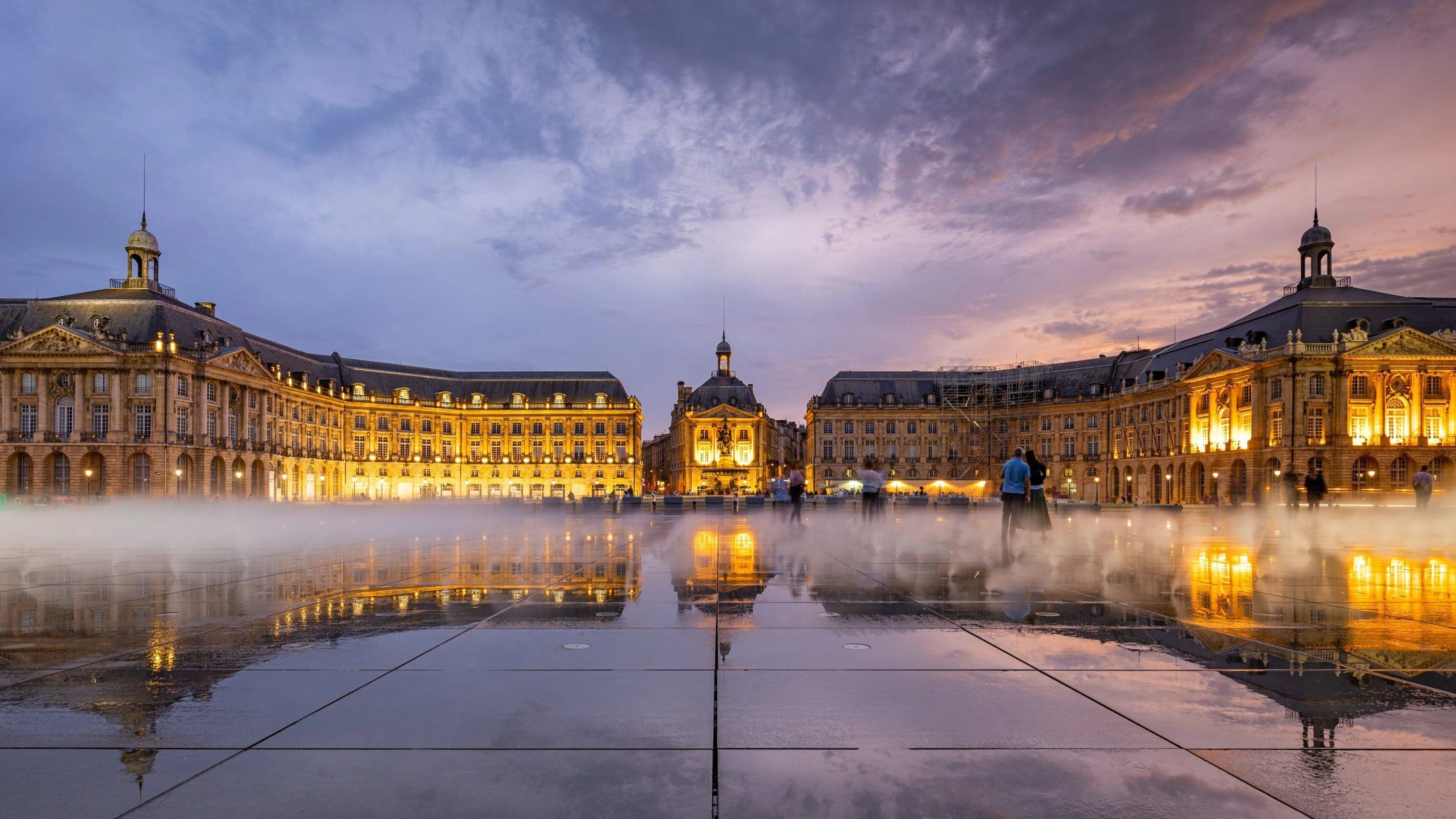 La place de la Bourse illuminée au crépuscule, reflétée dans le Miroir d’eau à Bordeaux